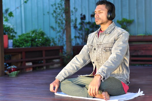 Binaural Beats Headphones - Adult man practicing meditation and relaxation with headphones in a serene outdoor setting.