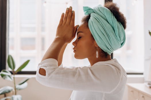 Mindvalley's Duality Review: Is It Suitable For You? Mindvalley Duality Review - Woman practicing meditation indoors with a focus on relaxation and mindfulness.