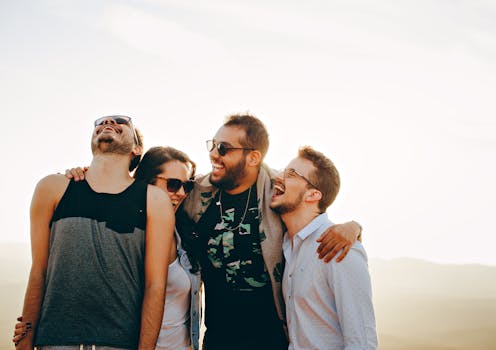 How to raise your vibration - A group of young adults laughing and enjoying time together outdoors under the sun.