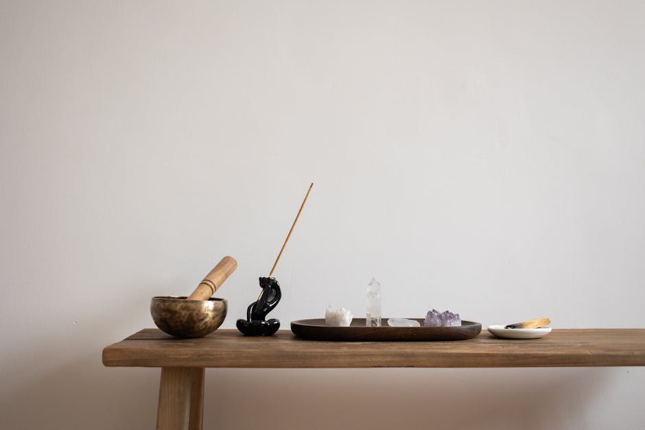 A serene setup featuring crystals, incense, and a singing bowl on a wooden table, perfect for meditation.