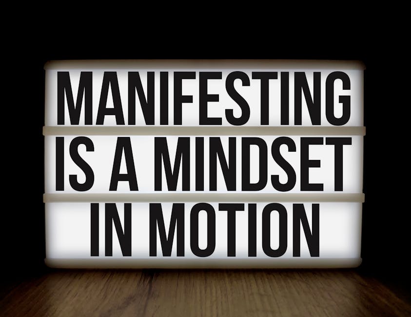 How to practice the Law of Attraction - Inspirational quote 'Manifesting is a mindset in motion' on lightbox over dark background.