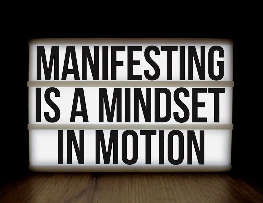 LibraMiser How to practice the Law of Attraction - Inspirational quote 'Manifesting is a mindset in motion' on lightbox over dark background.