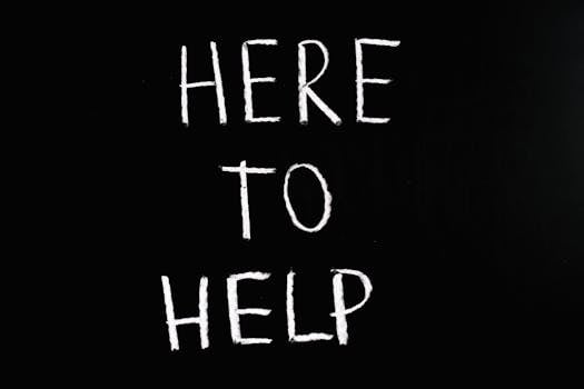 How to Contribute to a Better World - White text 'Here to Help' on a minimalist black chalkboard background, conveying encouragement and support.